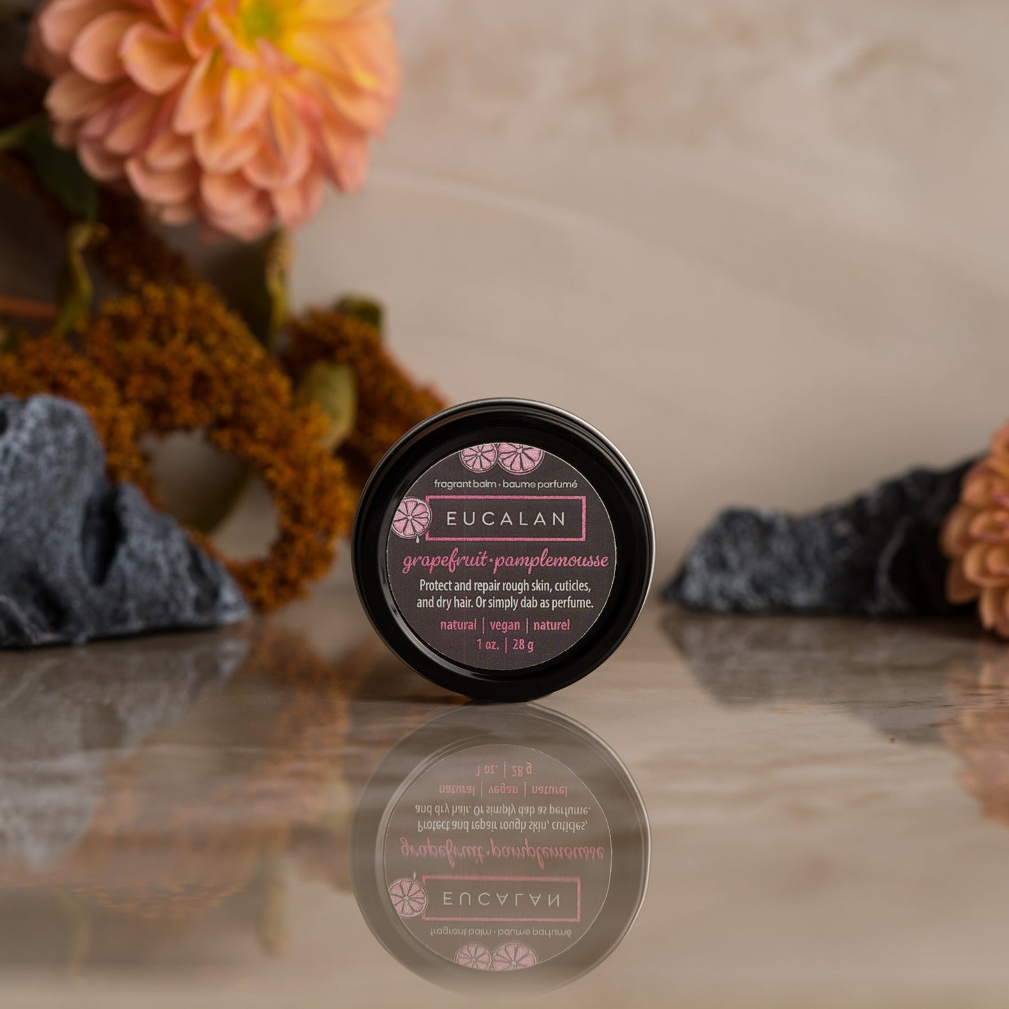 Eucalan product on a reflective surface with flowers and rocks in the background